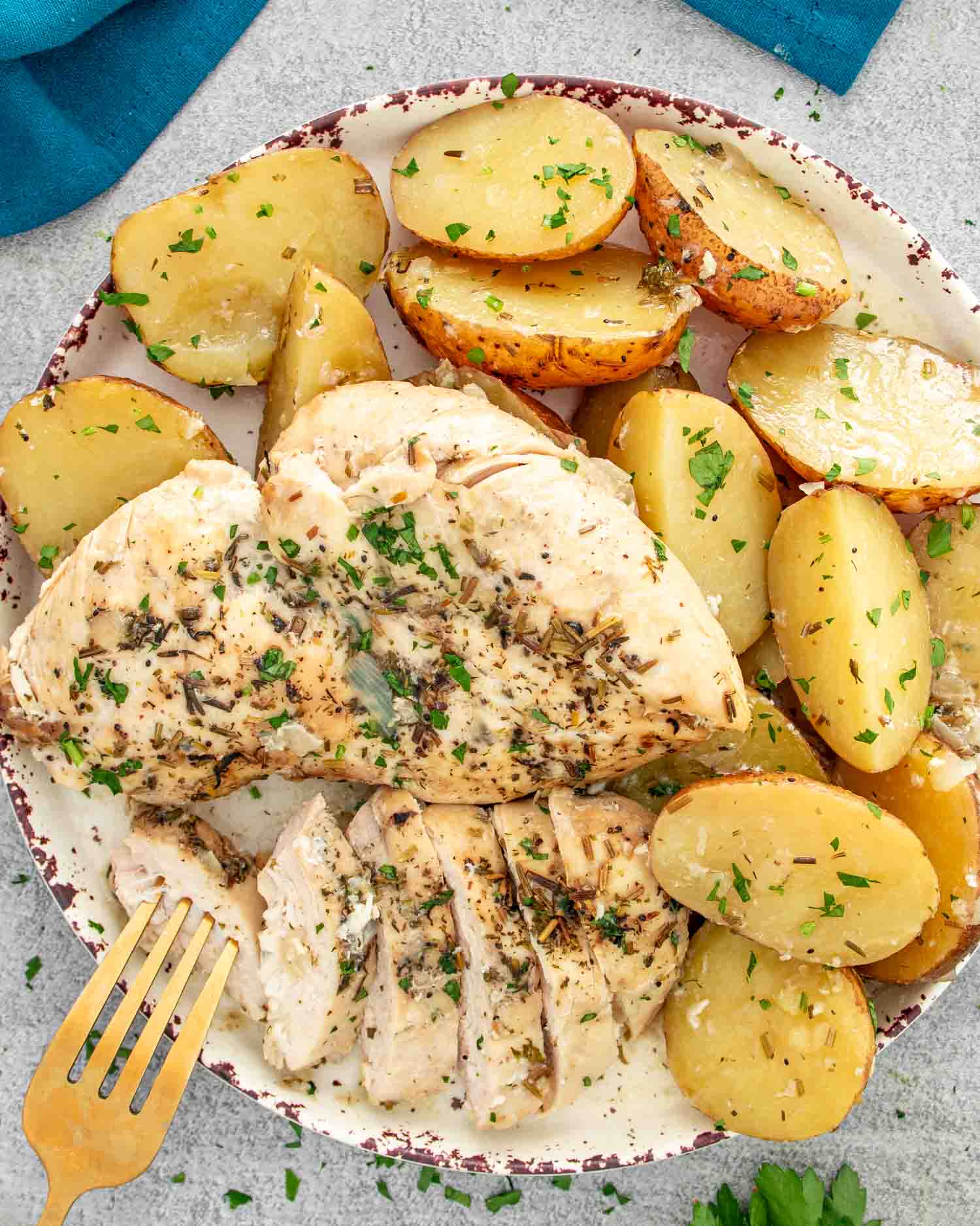 sliced up chicken breast and potatoes made in a crockpot, on a white plate.
