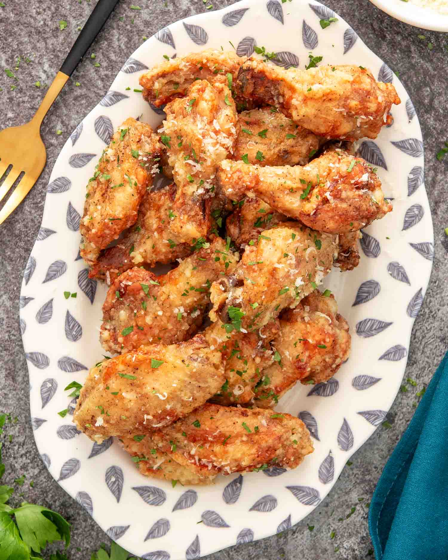 freshly made garlic parmesan wings on a white plate.