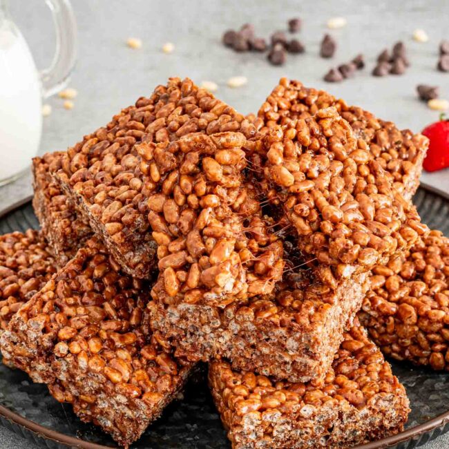 a stack of a few chocolate rice krispie treats on a plate.