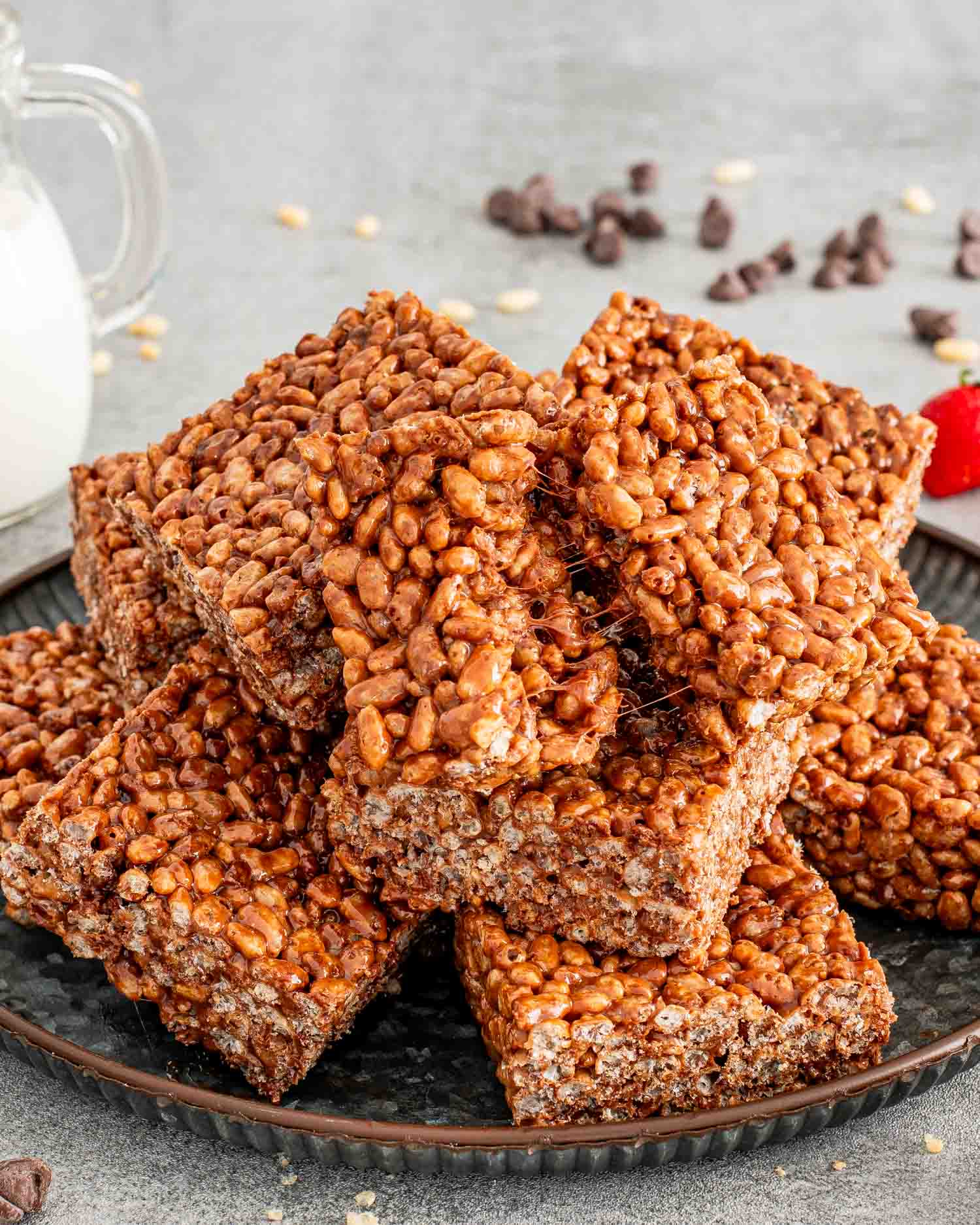 a stack of a few chocolate rice krispie treats on a plate.