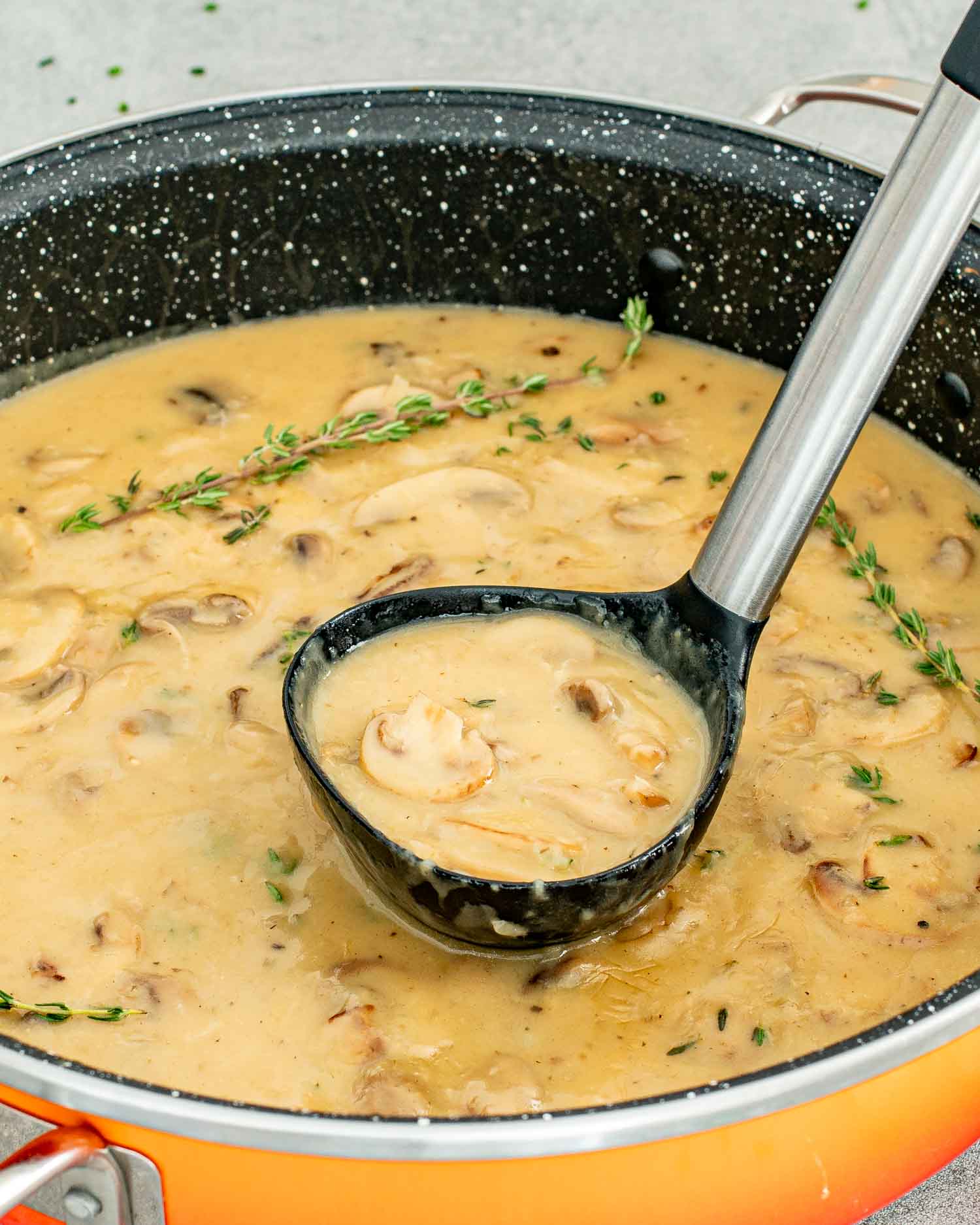 freshly made mushroom gravy in a pot with a ladle in it.