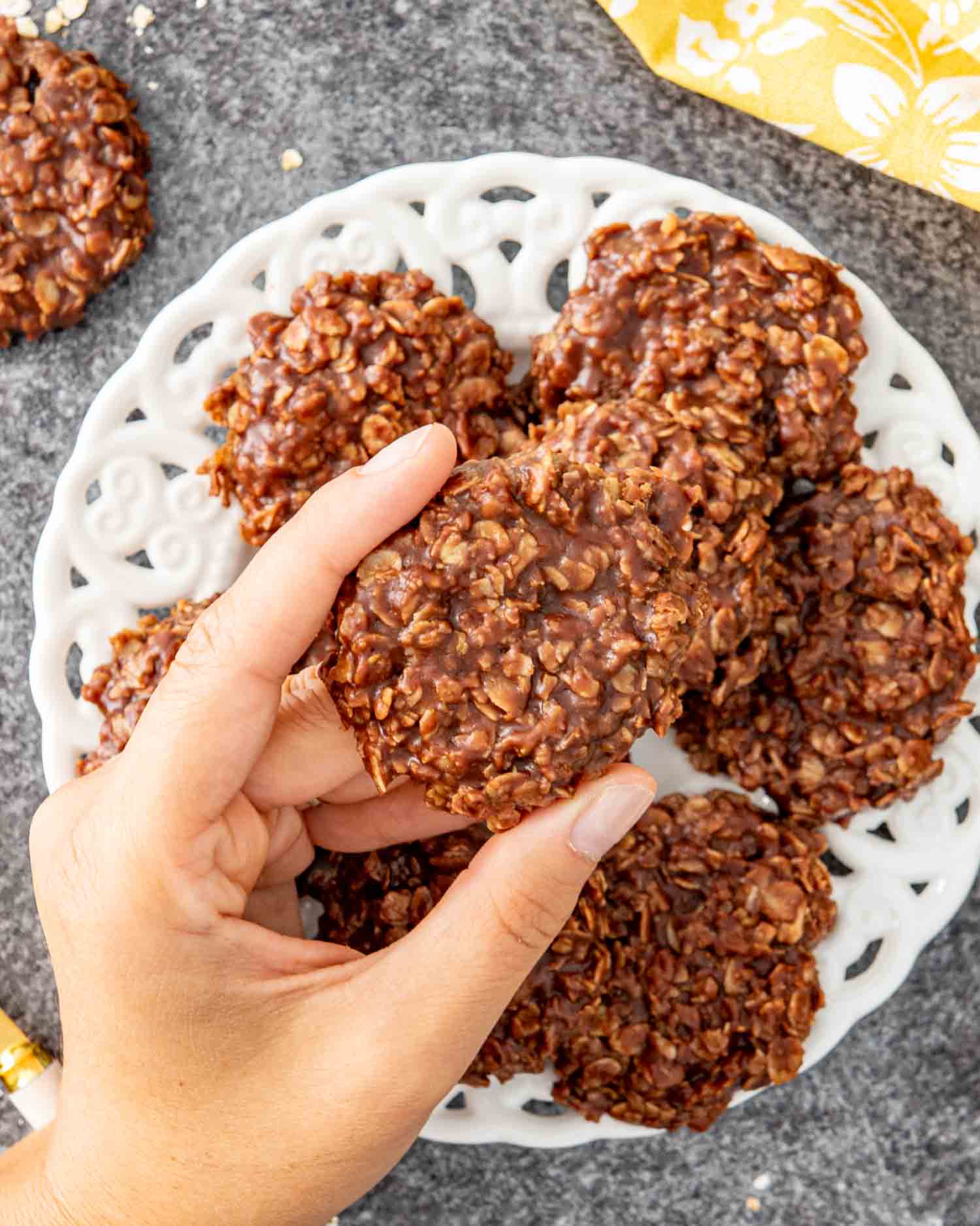 a stack of no bake chocolate oatmeal cookies on a white plate.