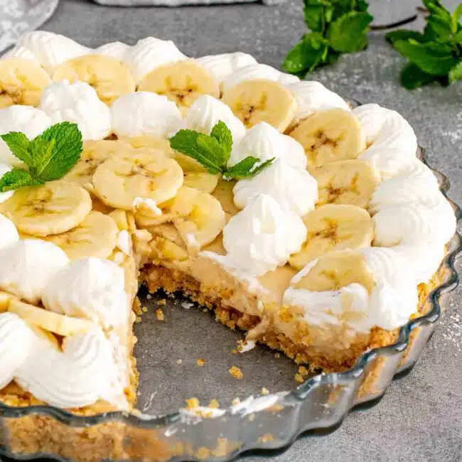 banana cream pie in a pie plate with a slice cut out.