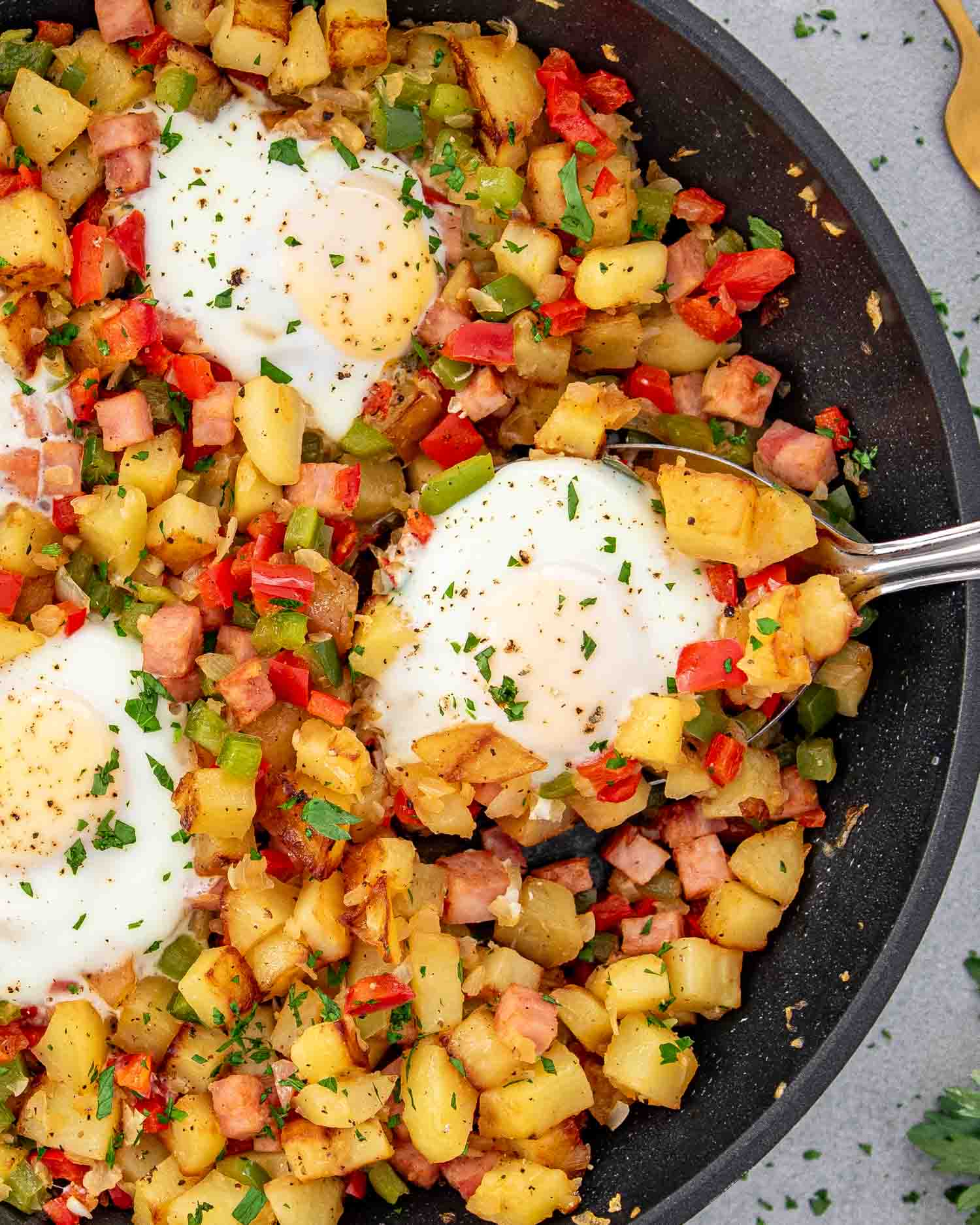 breakfast hash with 4 eggs in skillet.