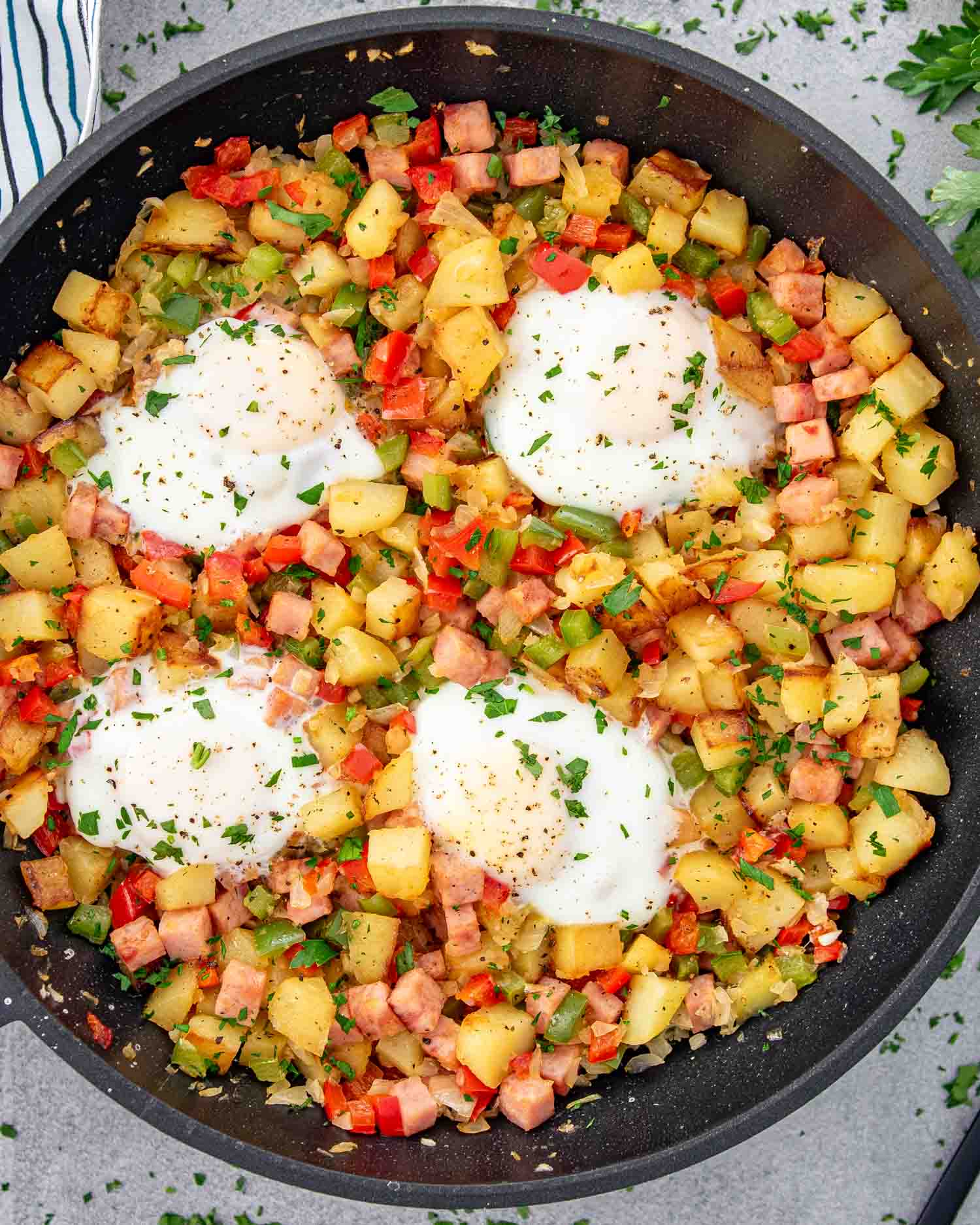 breakfast hash with 4 eggs in skillet.