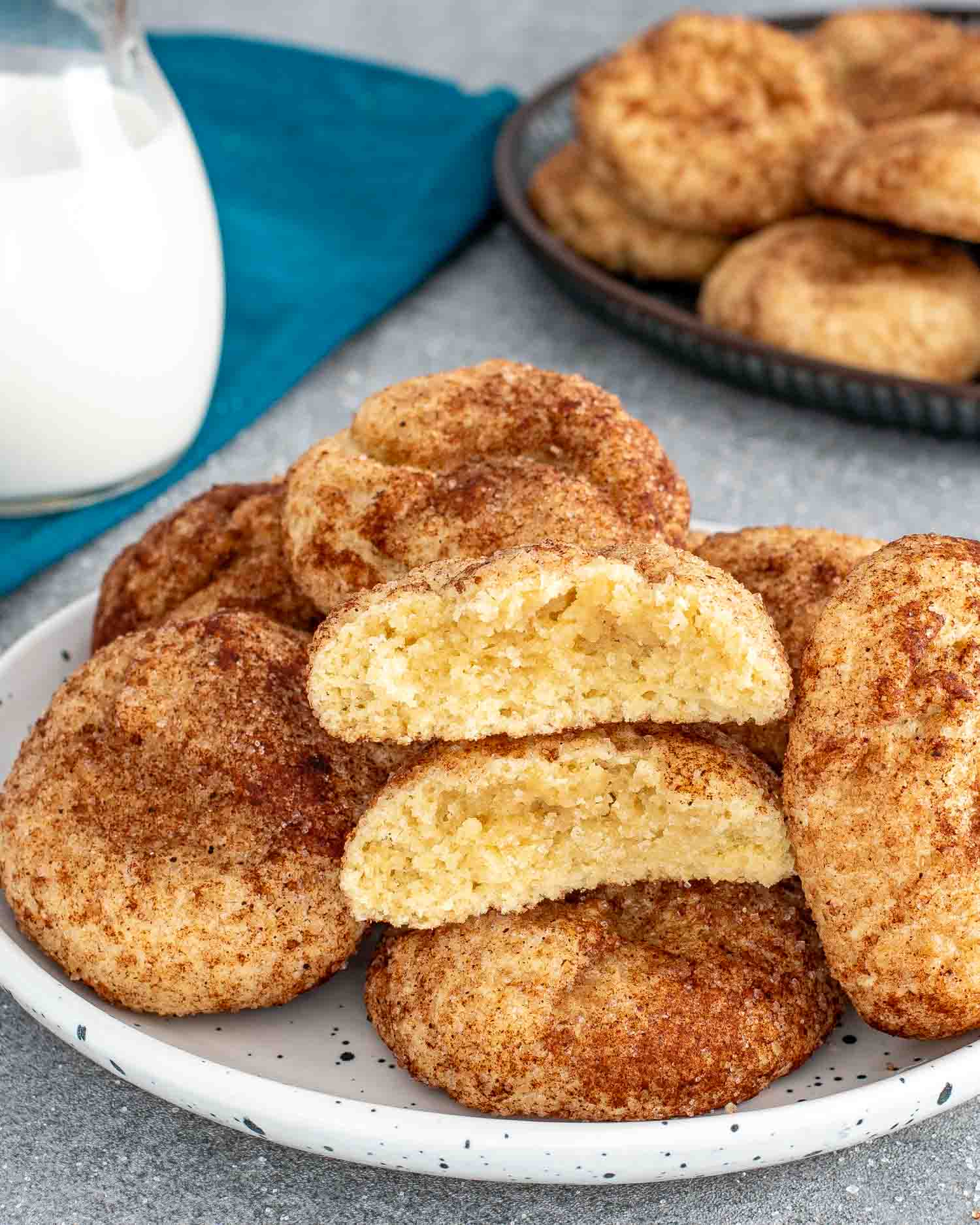snickerdoodle cookies with a glass of milk in the background.