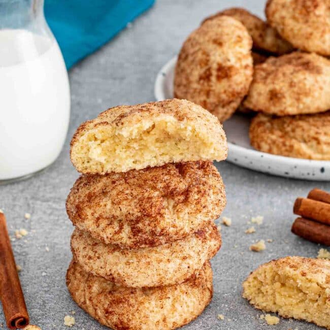 a stack of snickerdoodle cookies with a glass of milk.