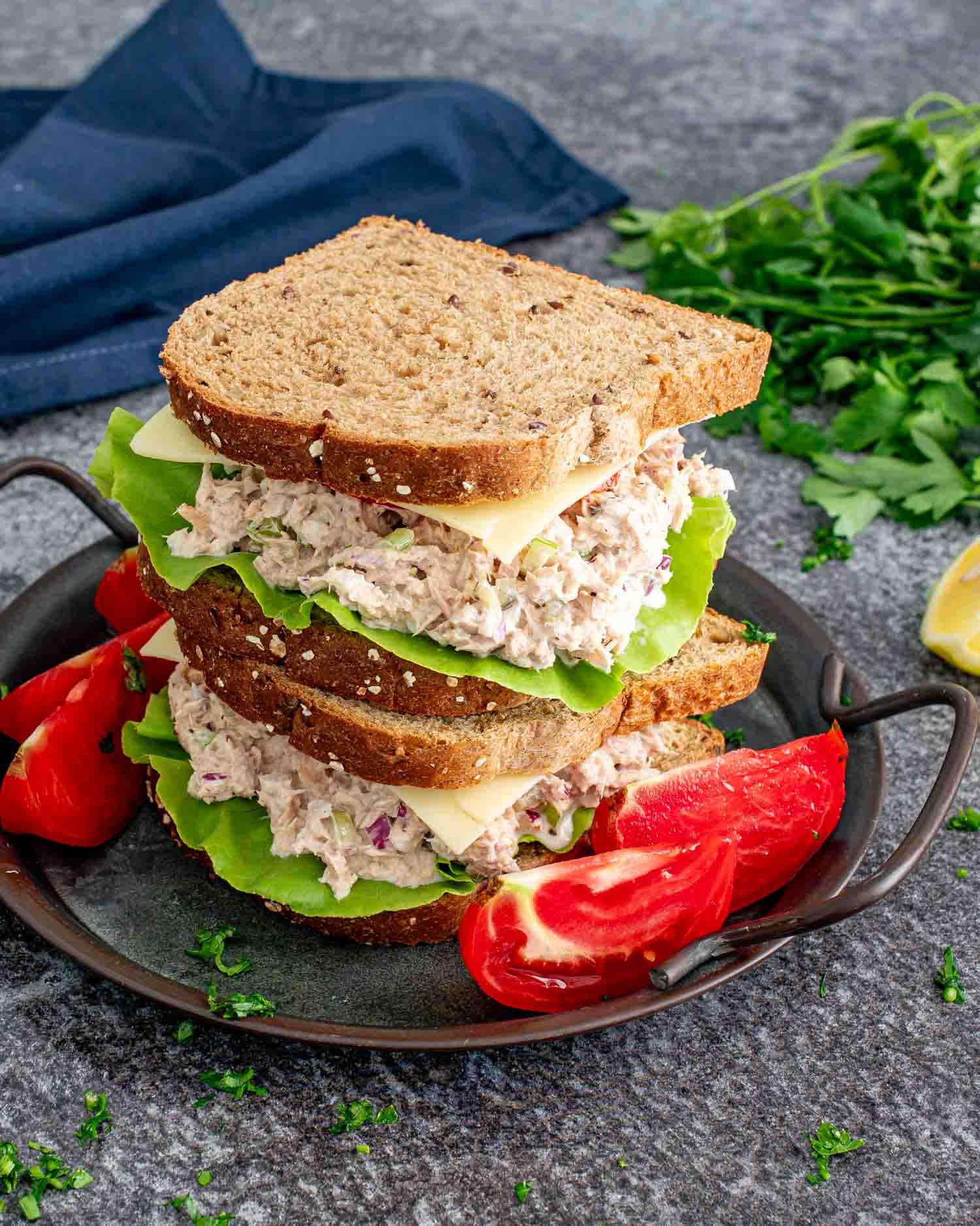 2 stacked tuna salad sandwiches on a plate.