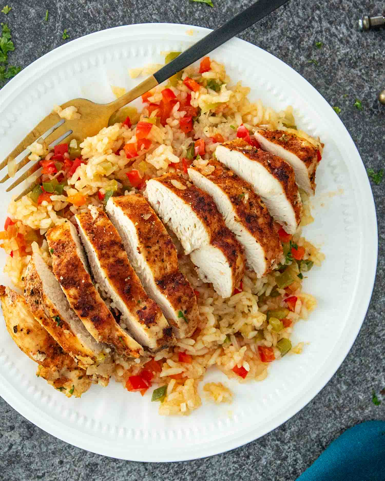 a cajun chicken breast and cajun rice on a plate.