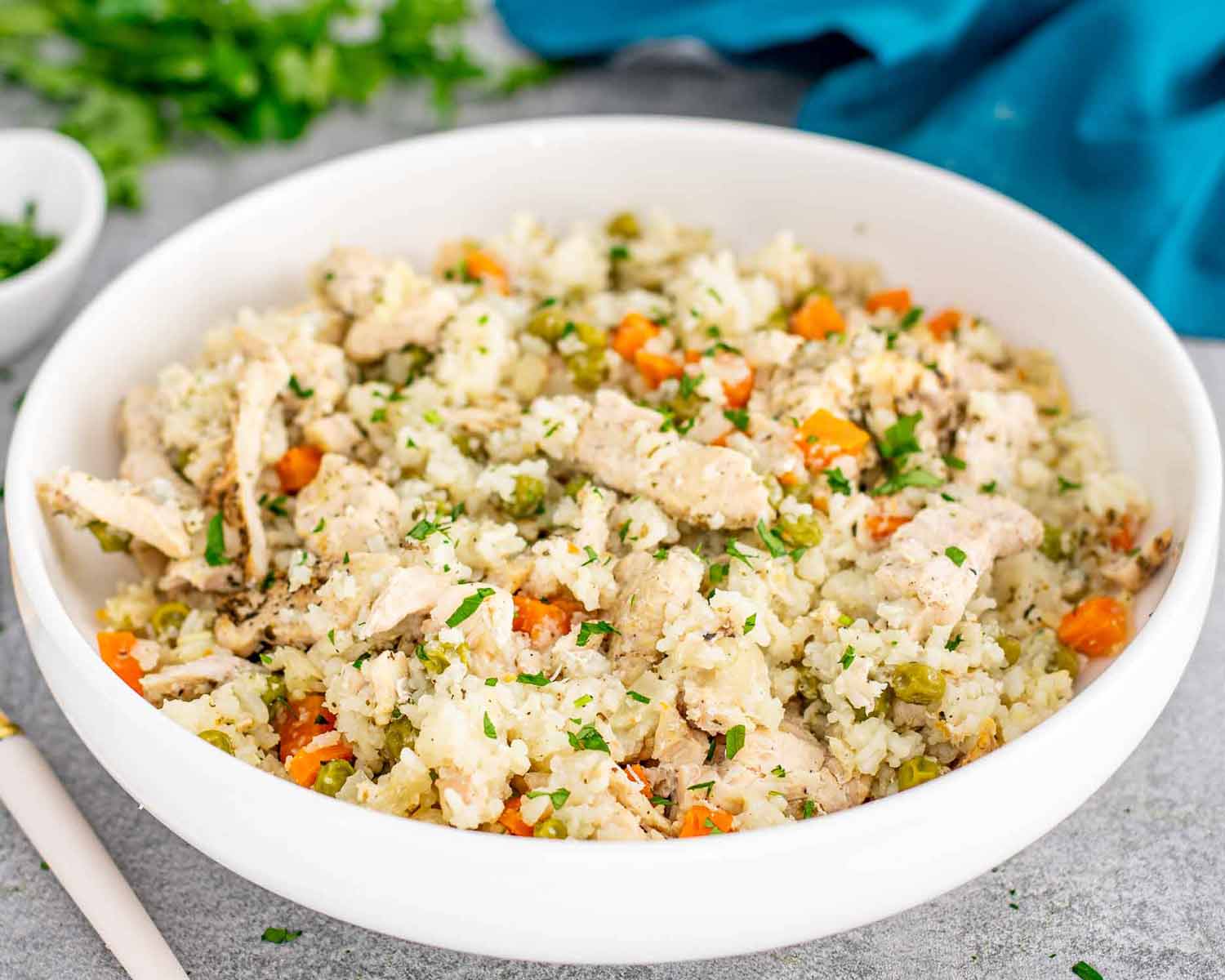 chicken and rice in a white serving bowl that was made in a crockpot.