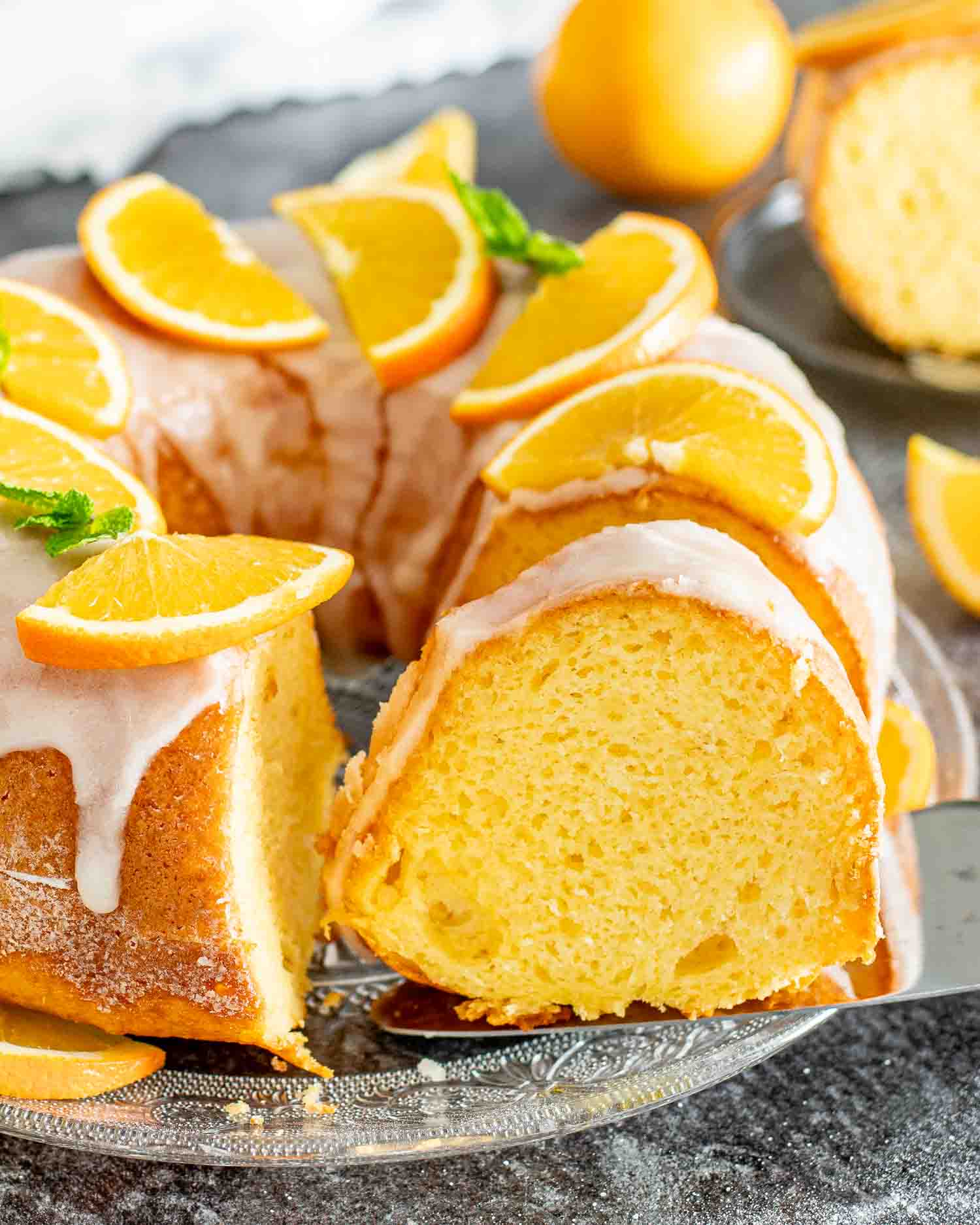 a freshly baked harvey wallbanger cake garnished with orange slices on a cake platter.