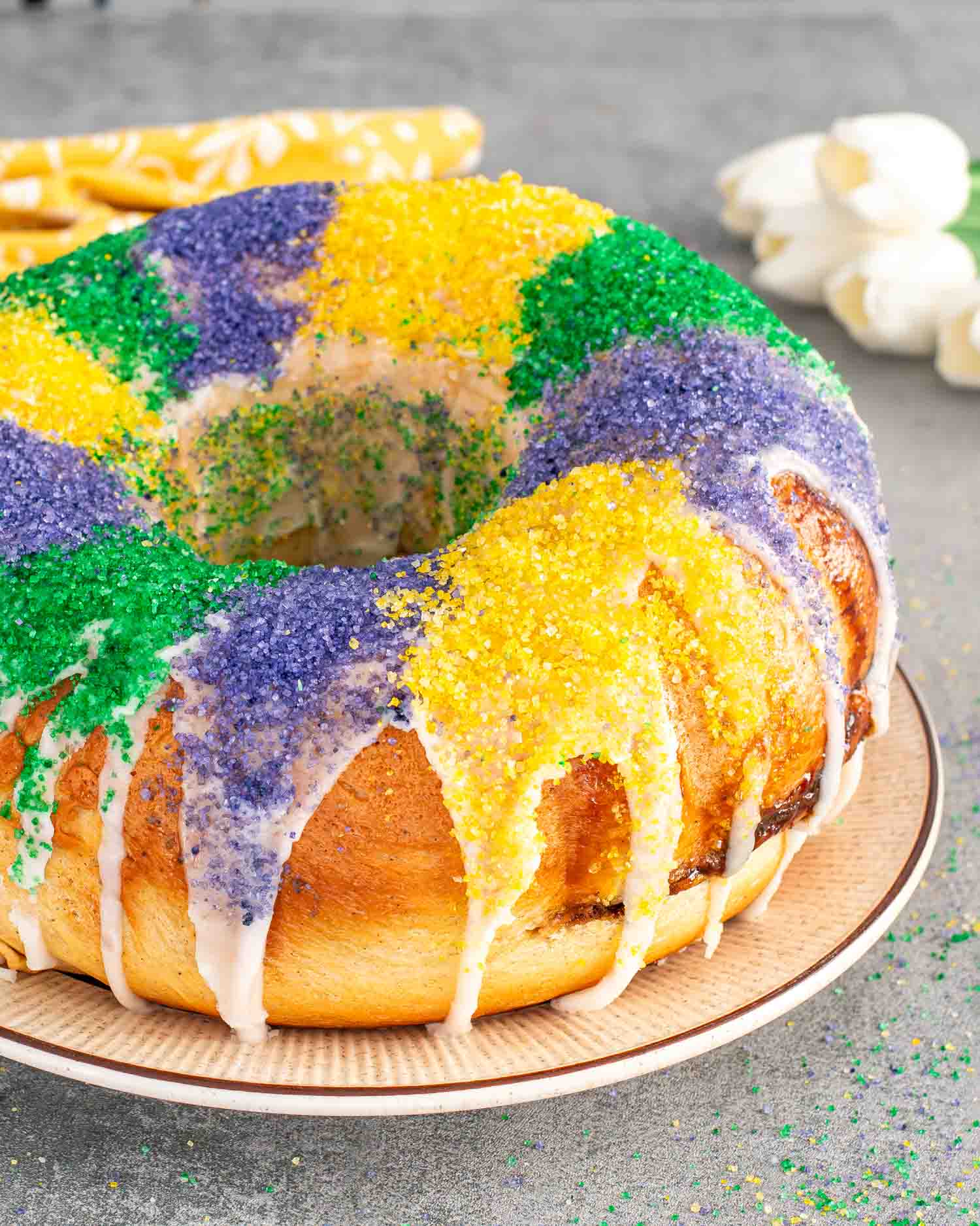 a gorgeous mardis gras king cake on a plate beautifully decorated.