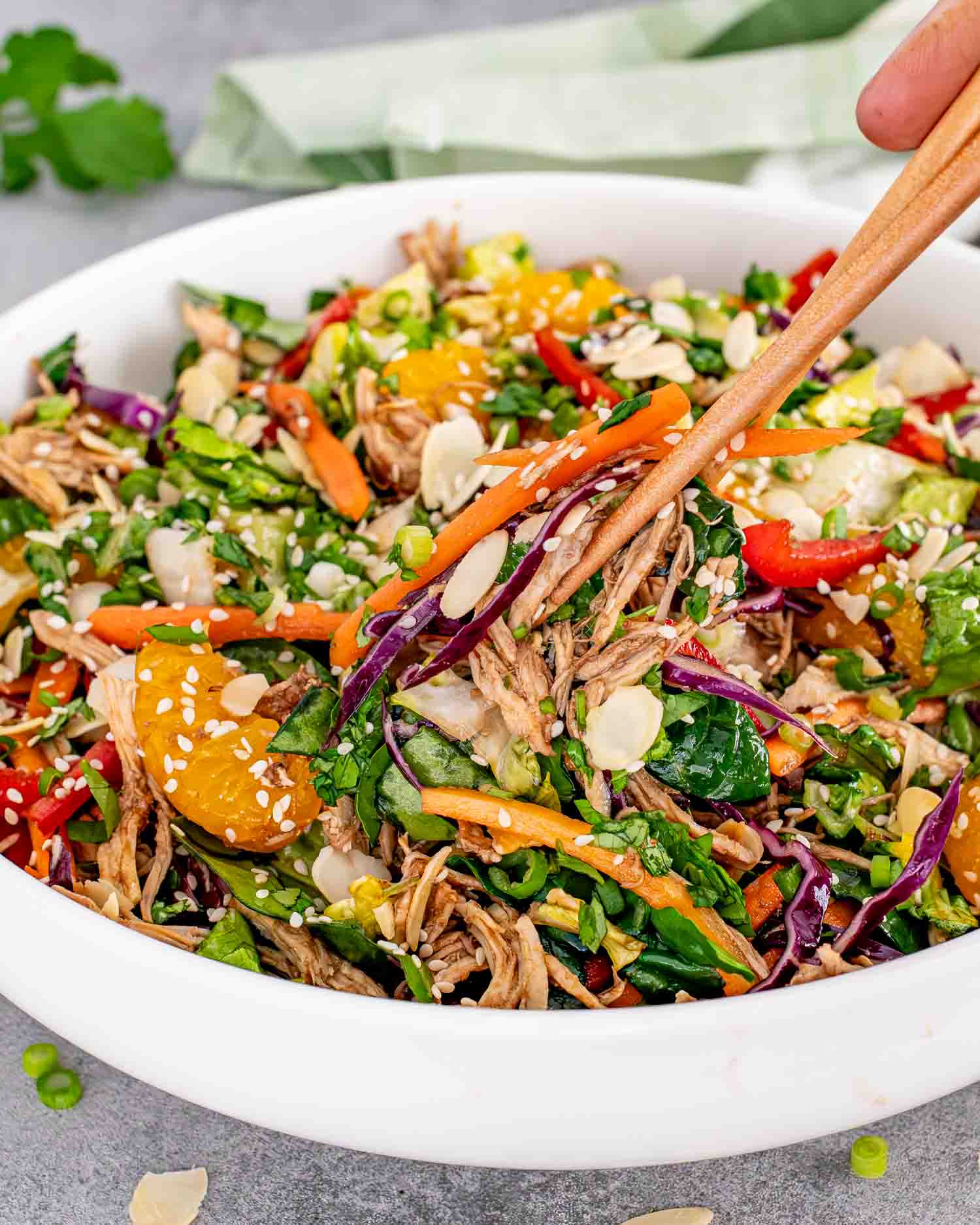 a gorgeous chinese chicken salad in a white salad bowl.