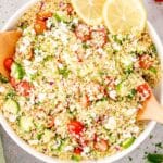 freshly made lemon cucumber couscous salad in a white bowl.