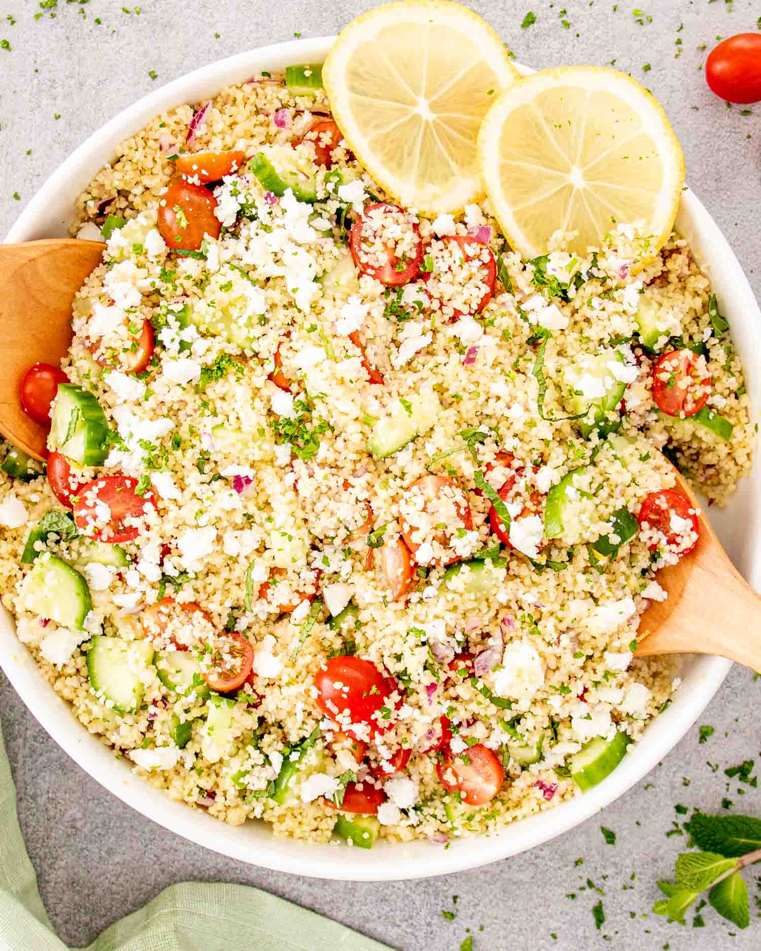 freshly made lemon cucumber couscous salad in a white bowl.