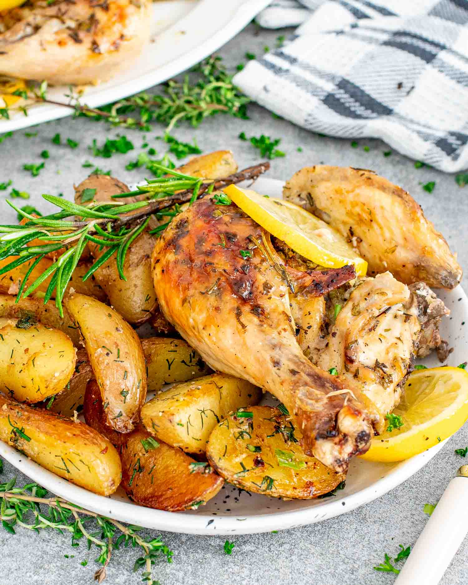 a serving of lemon garlic chicken on a plate along with some roasted potatoes.