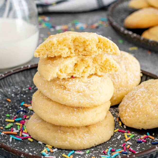 a stack of butter cookies with a glass of milk.