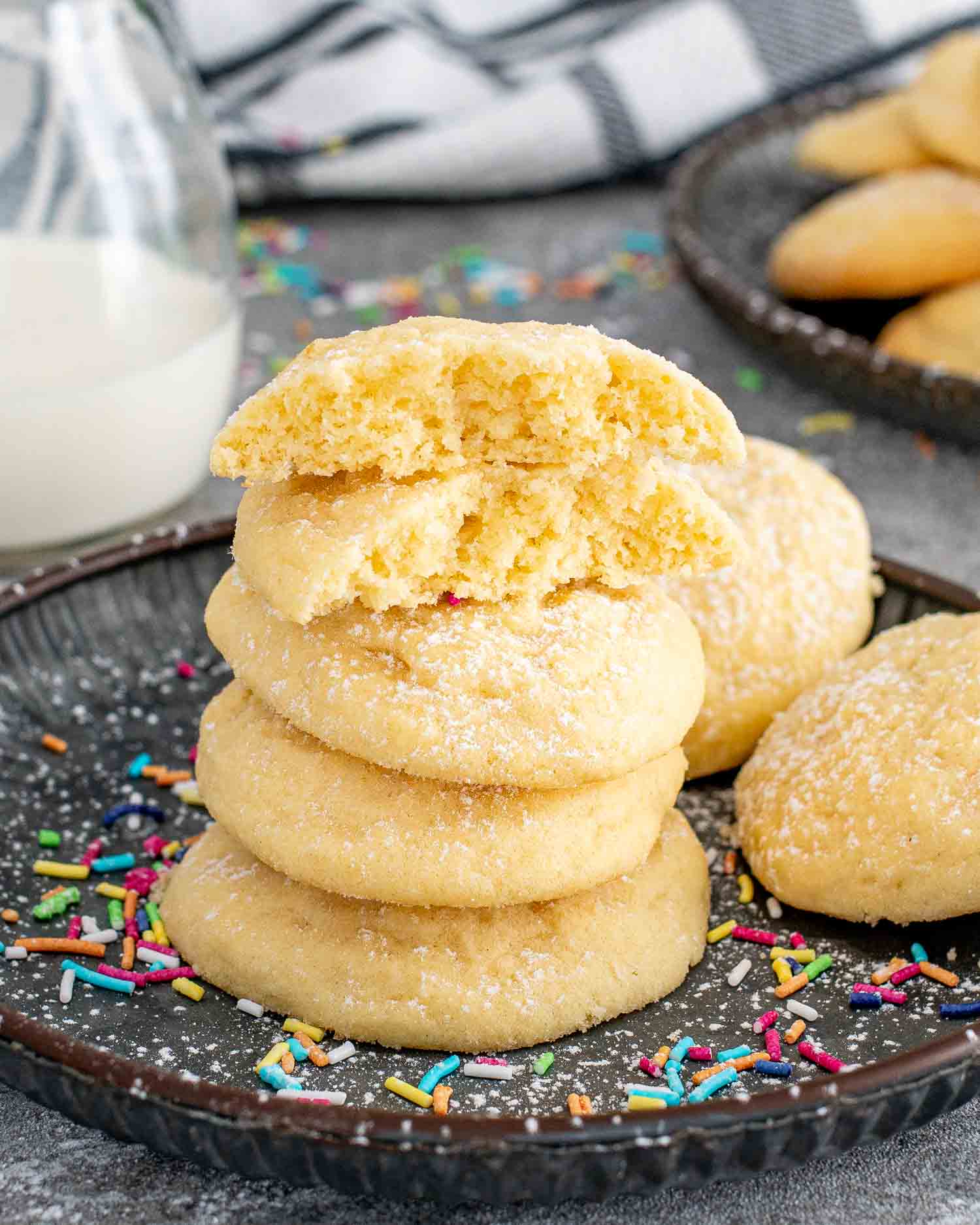 a stack of butter cookies with a glass of milk.