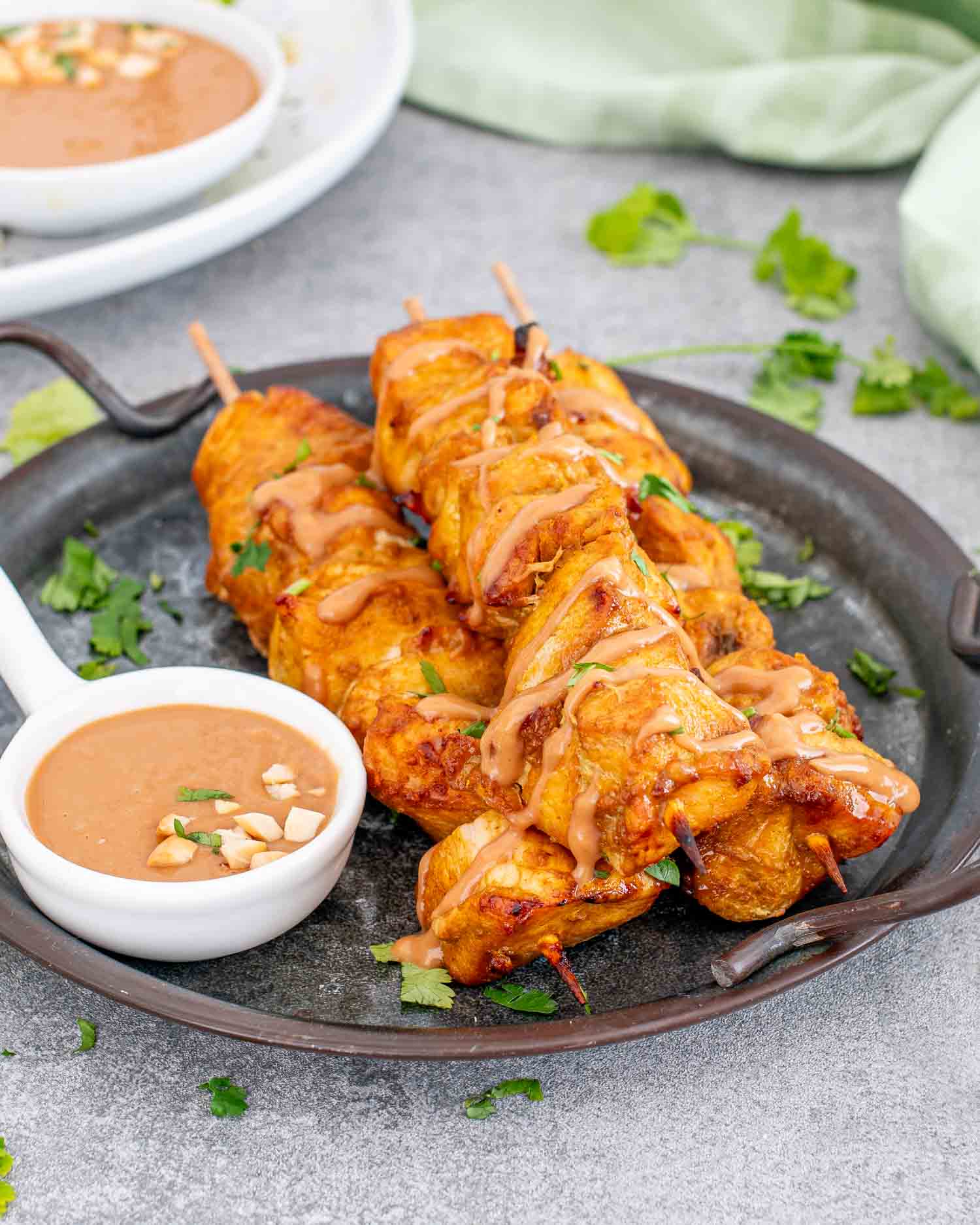 a serving of chicken satay with peanut sauce on a plate.