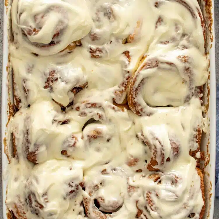 a pan of freshly made cinnamon rolls with icing.