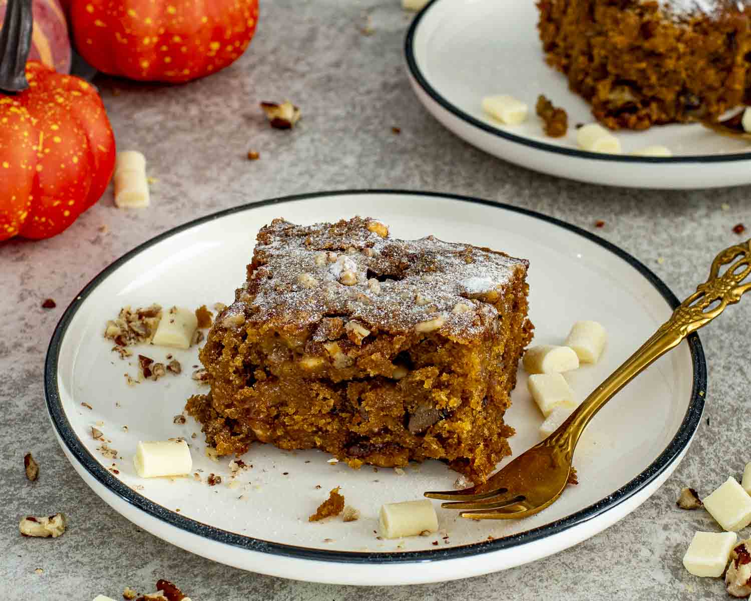 Pumpkin spice blondie square on a plate with autumn decor, highlighting rich brown sugar color and tender, chewy interior.
