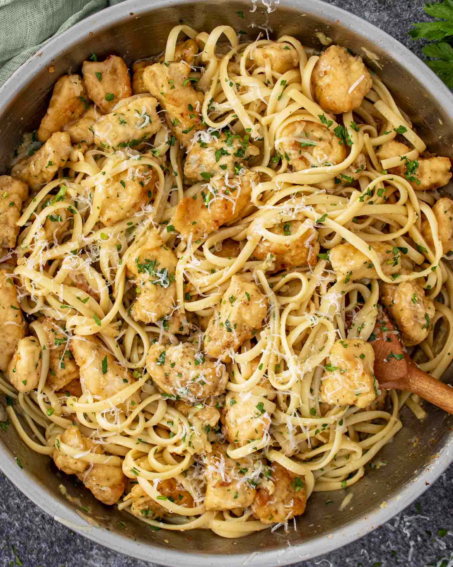 Chicken scampi cooked in a large skillet with golden chicken, linguine, Parmesan cheese, and garlic lemon butter sauce.