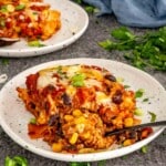 Close-up of beef enchilada casserole showing layers of seasoned ground beef, enchilada sauce, tortillas, and cheese.
