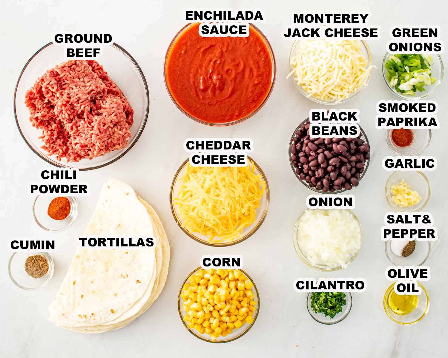 Ingredients for beef enchilada casserole including ground beef, enchilada sauce, tortillas, cheese, beans, corn, and spices.