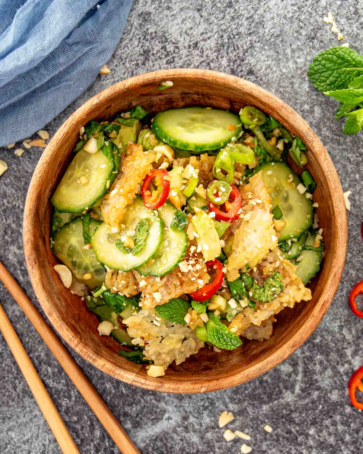 Cucumber salad with crispy rice, fresh herbs, sliced chili, peanuts, and lime, tossed in a glossy sesame dressing.