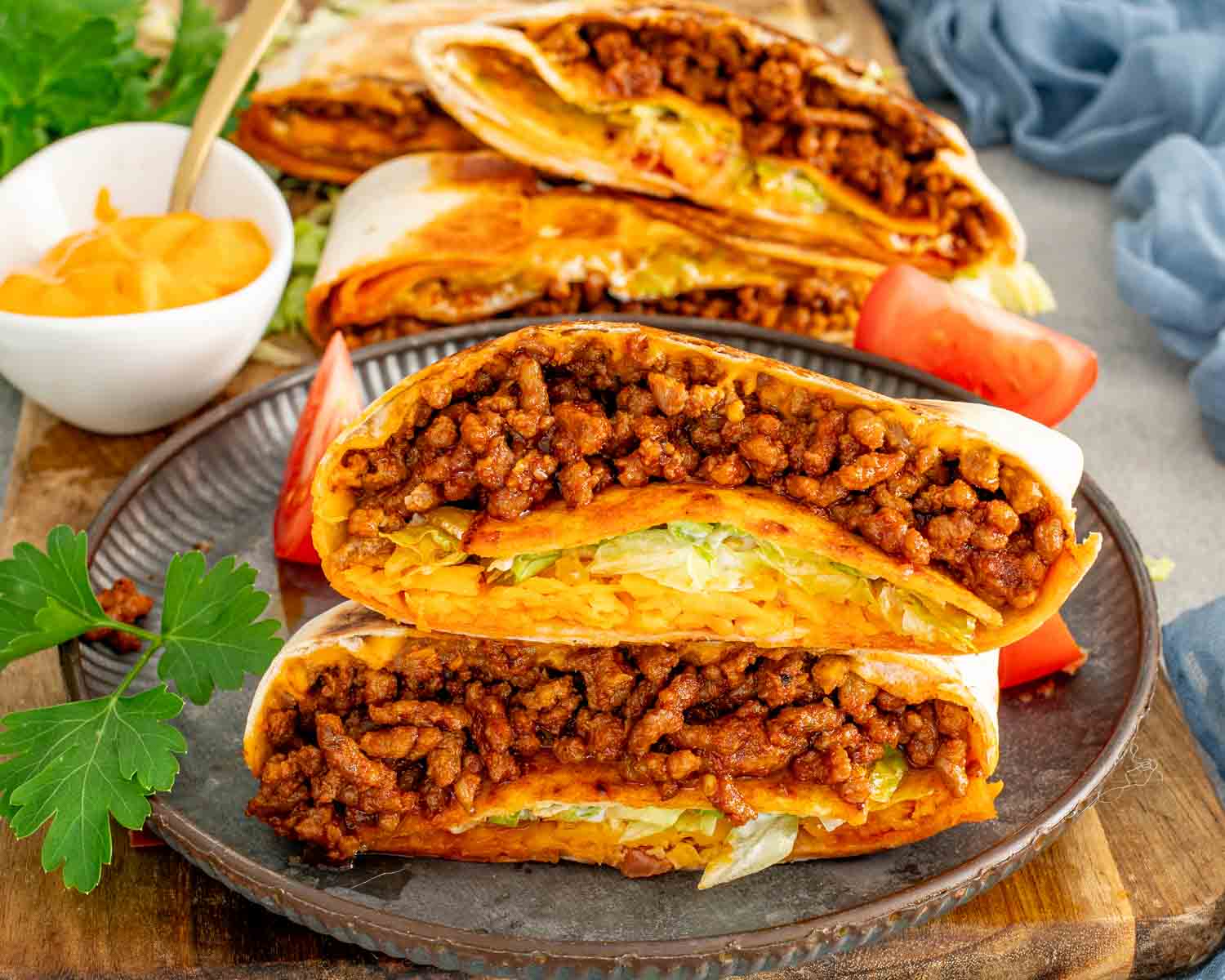 Homemade Crunchwrap Supreme copycat sliced open, showing golden toasted tortilla, taco meat, nacho cheese, and lettuce.