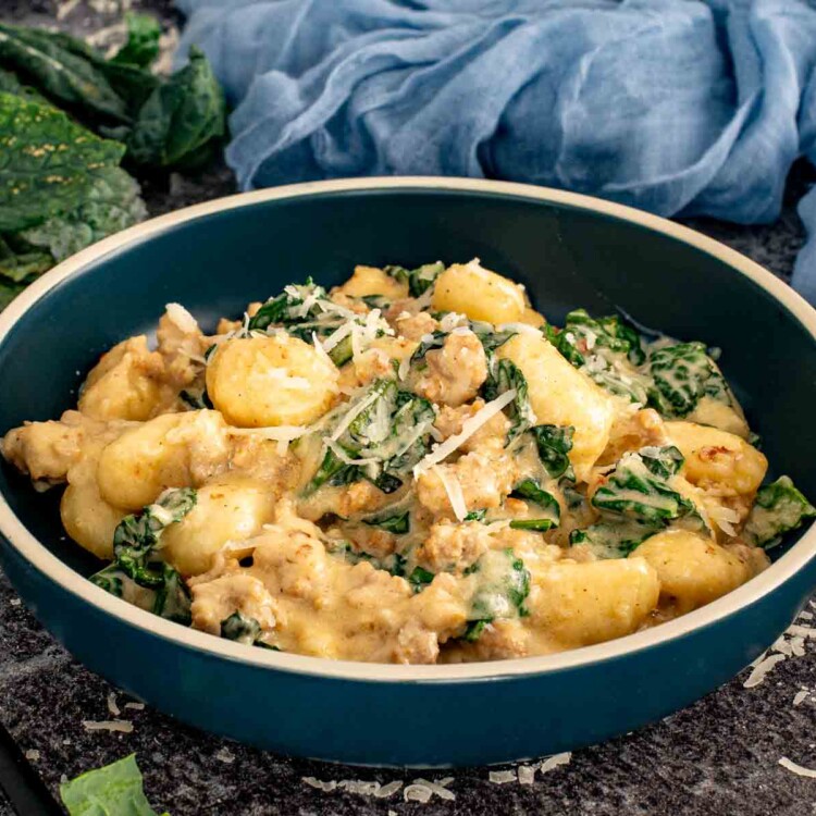 Bowl of creamy gnocchi with sausage and kale topped with grated Parmesan and served with a spoon. 4. Slightly wider bowl shot