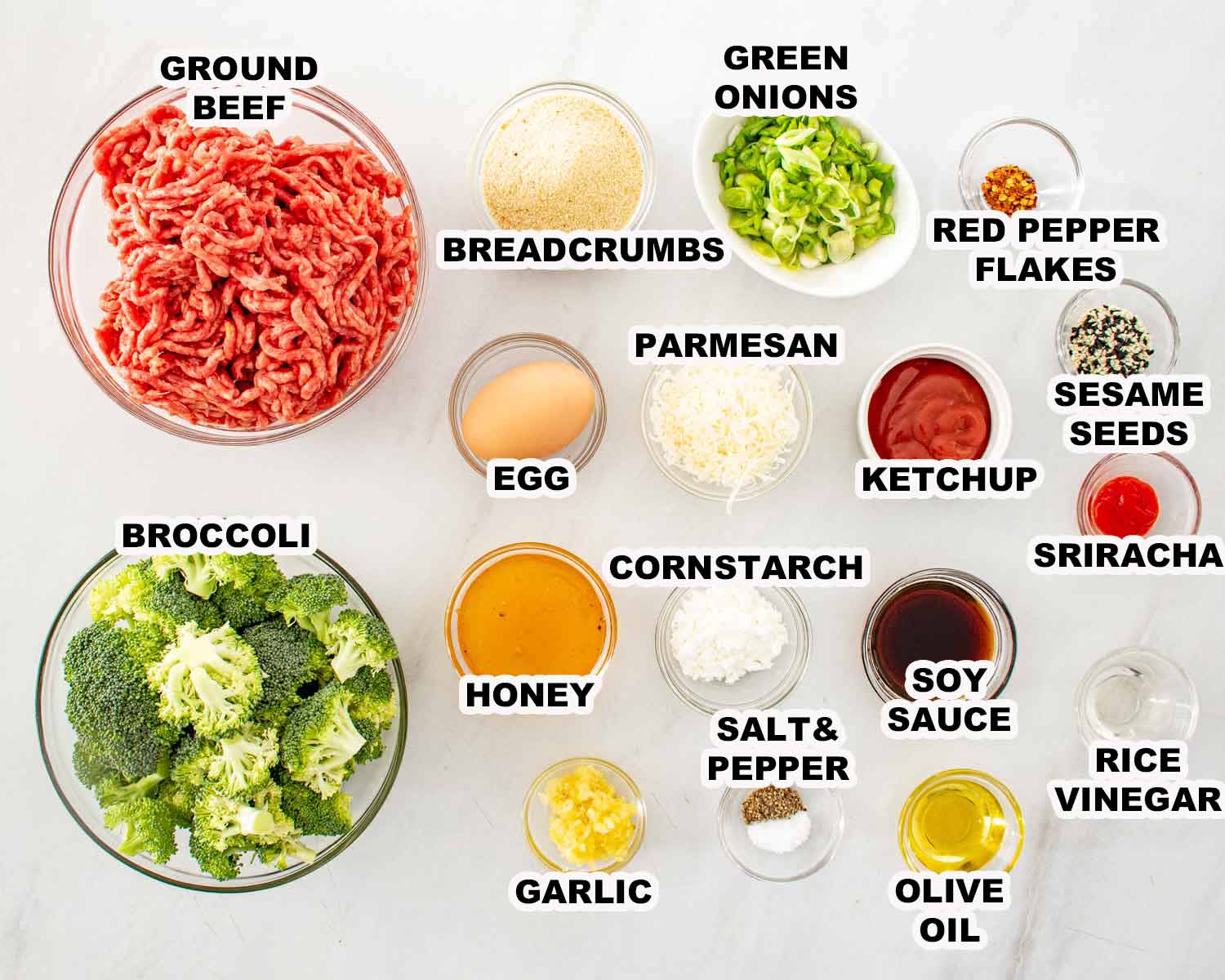 Overhead view of ingredients for meatballs including ground beef broccoli honey soy sauce garlic and red pepper flakes.