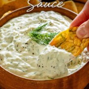 Pinterest graphic featuring creamy tzatziki sauce in a wooden bowl with a dipping chip and elegant recipe title.