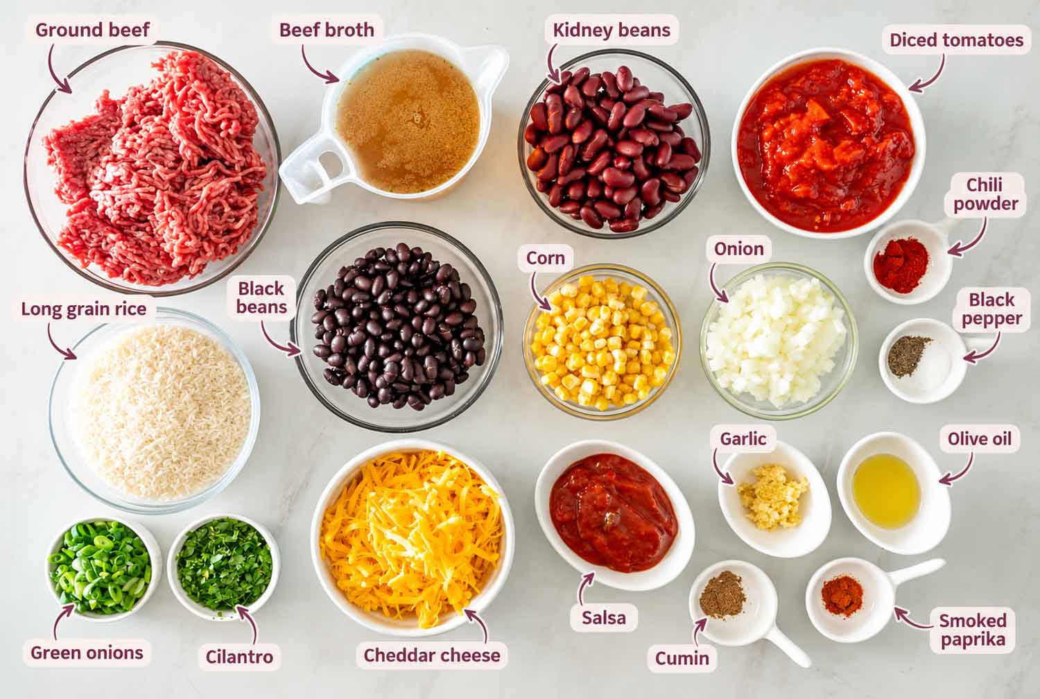 Labeled ingredients for chili rice bake, including ground beef, rice, beans, corn, tomatoes, cheddar, broth, salsa, herbs, and spices.